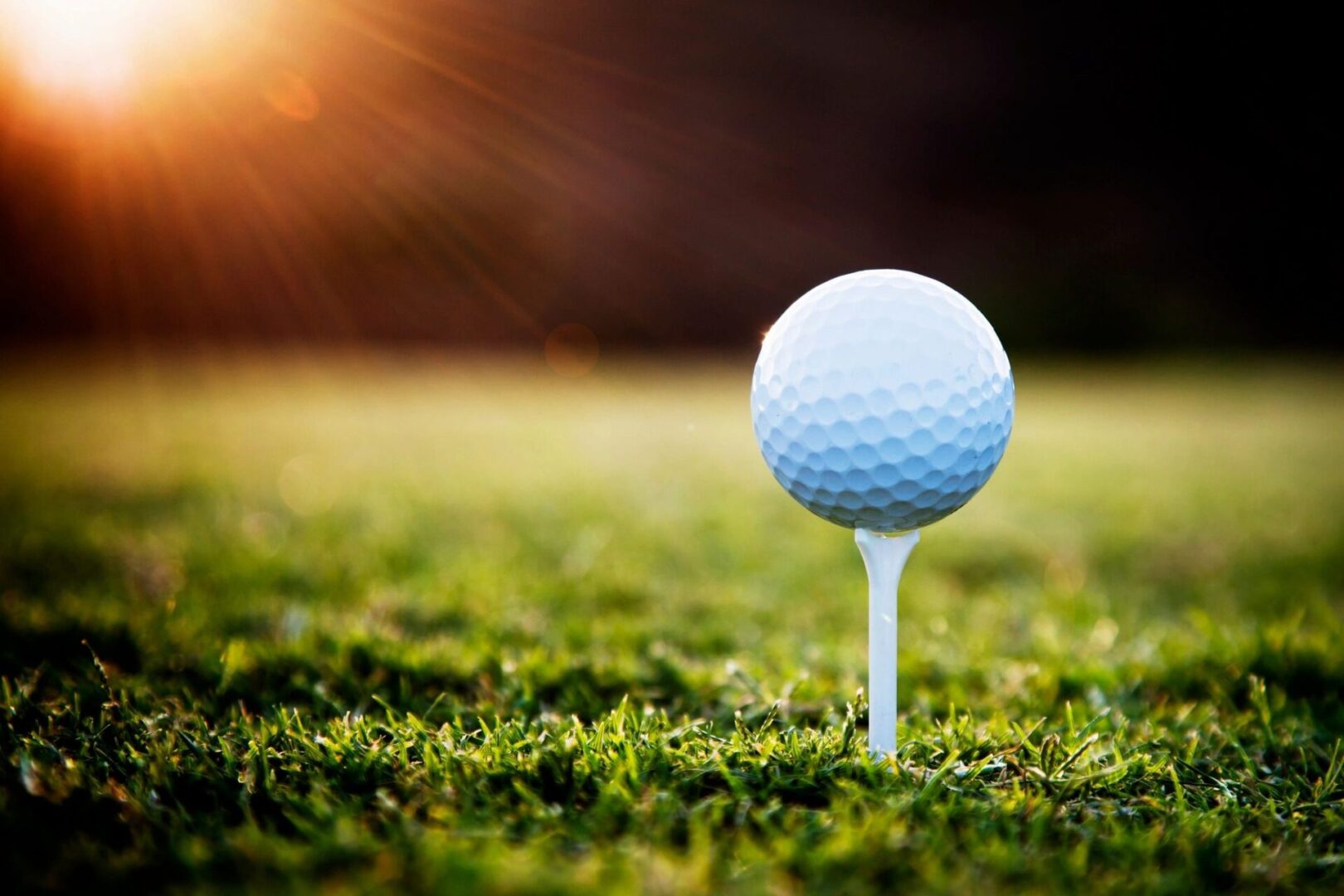 A close up of a golf ball on top of a tee.